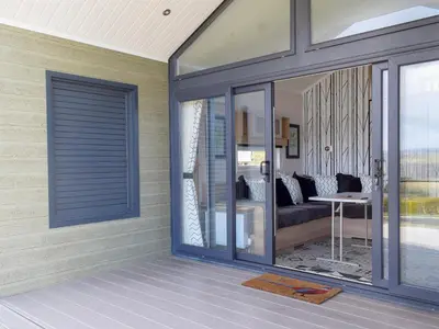 a living room with a sliding glass door at Lake Vyrnwy Luxury Glamping Pod 2 in Llanwddyn