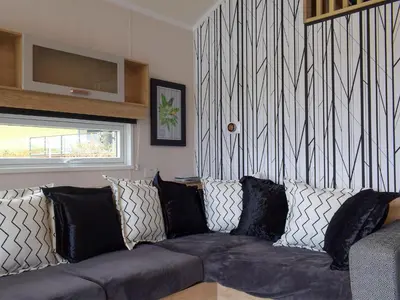 a living room with a couch with black and white pillows at Lake Vyrnwy Luxury Glamping Pod 2 in Llanwddyn