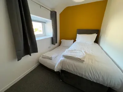 a small bedroom with a bed and a window at Escapism Wales Garthowen in Llanrhystyd