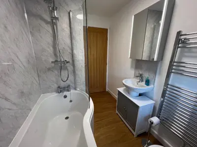 a bathroom with a white tub and a sink at Escapism Wales Garthowen in Llanrhystyd
