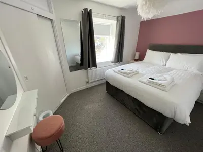 a bedroom with a large bed and a mirror at Escapism Wales Garthowen in Llanrhystyd