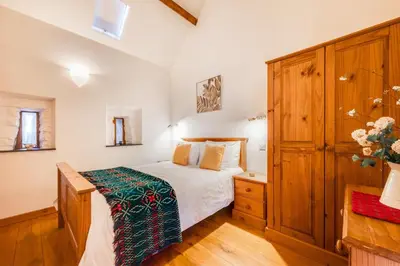 a bedroom with a bed and a wooden cabinet at 2 Bed in Dolgellau oc-bow284 in Trawsfynydd