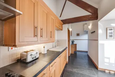 a kitchen with wooden cabinets and a counter top at 2 Bed in Dolgellau oc-bow284 in Trawsfynydd