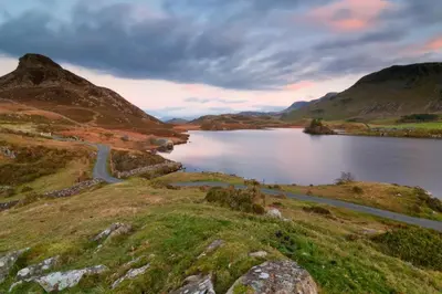 a lake in the middle of a mountain with a road at 2 Bed in Dolgellau oc-bow284 in Trawsfynydd