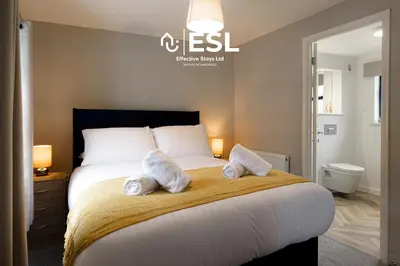 a bedroom with a large bed with towels on it at Comfy Modern 2 Bedroom Duplex Apartment with Sun Terrace in Shrewsbury