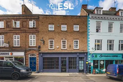 a brick building with cars parked in front of it at Comfy Modern 2 Bedroom Duplex Apartment with Sun Terrace in Shrewsbury