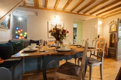 a dining room with a table and a christmas tree at Cosy, coastal cottage in Snowdonia in Harlech