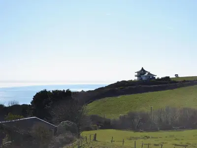 a house on top of a hill with a green field at Seascape in Aberystwyth