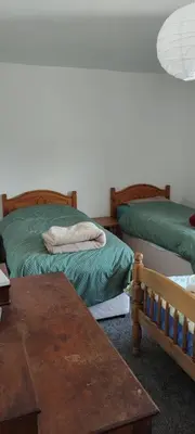 a room with two beds and a table and a tableasteryasteryasteryasteryastery at Toad Hall Hostel in Machynlleth