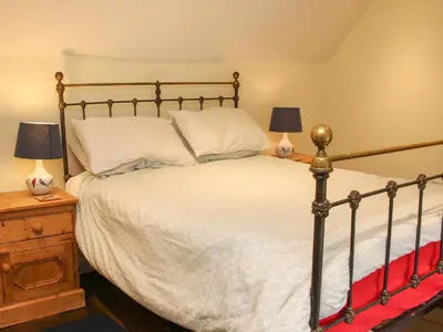 a bedroom with a large bed with two lamps at Denbigh Hall in Leominster