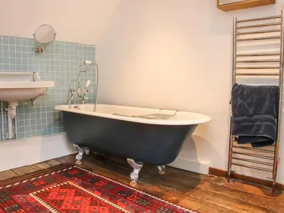a bath tub and a sink in a bathroom at Denbigh Hall in Leominster