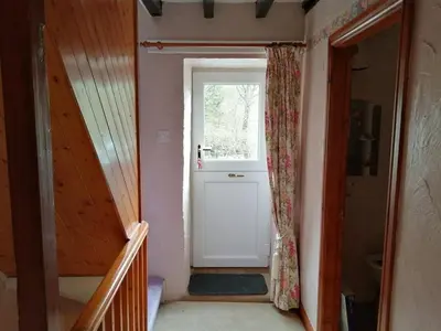a hallway with a white door and a window at 1 Park Terrace in Corris