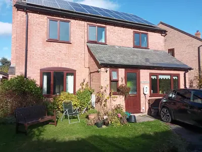 a brick house with solar panels on the roof at Swn Y Gwy ~ The Sound of the Wye in Brecon