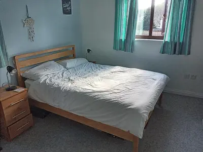 a bedroom with a bed and a dresser and a window at Swn Y Gwy ~ The Sound of the Wye in Brecon
