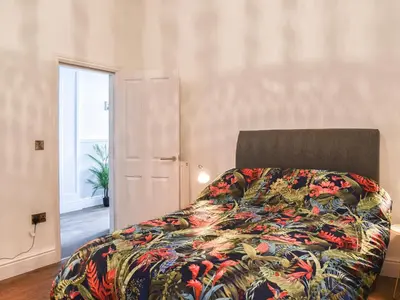 a bedroom with a bed with a colorful blanket at Ty Isaf in Barmouth