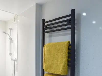 a towel rack in a bathroom with a yellow towel at Ty Isaf in Barmouth
