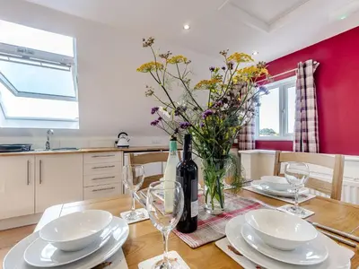 a dining room table with a bottle of wine and glasses at Penceunant in Penuwch