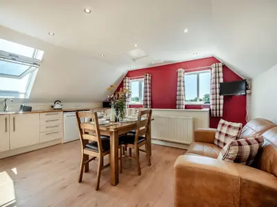 a kitchen and living room with a table and a couch at Penceunant in Penuwch