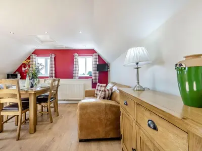 a living room with a table and a dining room at Penceunant in Penuwch