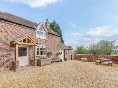 an external view of a brick house with a patio at Little Whitley - Uk38099 in Great Hanwood