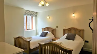a room with two beds and a table at Sheep Dip Cottage - 5* Cyfie Farm, with log burner and private hot tub in Llanfyllin