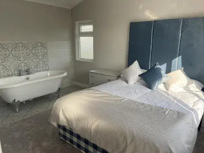 a bedroom with a large bed and a bath tub at Sea Breeze Lodge in Aberaeron