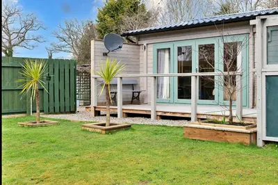 a house with two palm trees in a yard at Finest Retreats - Garden Lodge in Craven Arms