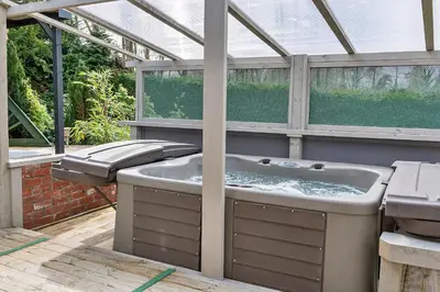 a hot tub in a greenhouse in a garden at Finest Retreats - Garden Lodge in Craven Arms
