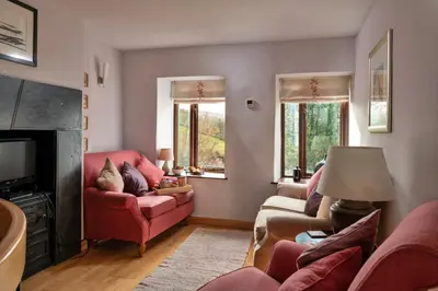 a living room with red furniture and a fireplace at Finest Retreats - Dolwar Cottage in Ffestiniog
