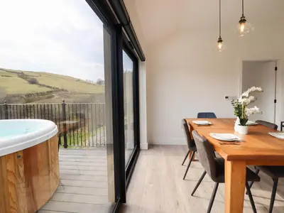 a dining room with a table and a bath tub at The Sheep Shed in Oswestry