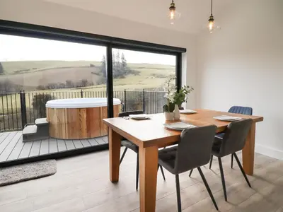 a dining room with a table and a tub at The Sheep Shed in Oswestry