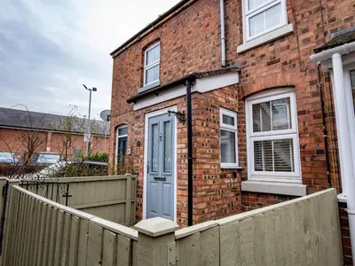 a brick house with a blue door and a fence at Central cosy home 5 minutes walk from Shrewsbury - Pass the Keys in Shrewsbury