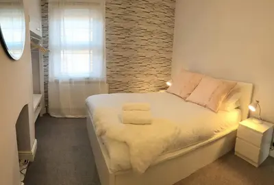 a bedroom with a white bed with a brick wall at Central cosy home 5 minutes walk from Shrewsbury - Pass the Keys in Shrewsbury