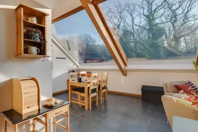 a living room with a window and a table and chairs at 2 Bed in Dolgellau oc-bow282 in Trawsfynydd