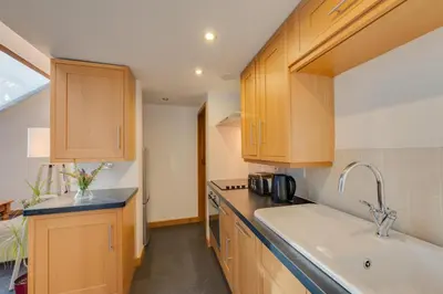 a kitchen with wooden cabinets and a sink at 2 Bed in Dolgellau oc-bow282 in Trawsfynydd