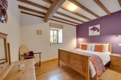 a bedroom with a king sized bed and purple walls at 2 Bed in Dolgellau oc-bow282 in Trawsfynydd