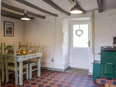 a kitchen with a table and chairs and a door at Blaen Y Cwm in Carno