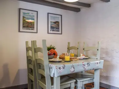 a dining room table with chairs and food on it at Blaen Y Cwm in Carno