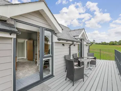 a patio with a table and chairs on a deck at Upper Bryn Y Groes in New Bridge