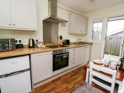 a kitchen with white cabinets and a counter top at Primrose Cottage in Llandrindod Wells