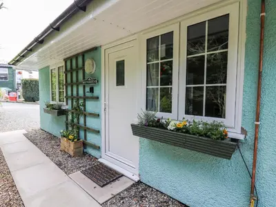 a front door of a house with flowers in window boxes at Honeysuckle Cottage in Llandrindod Wells
