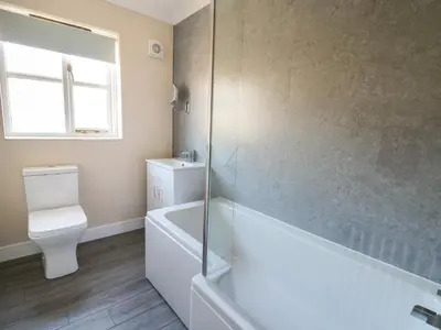 a bathroom with a tub and a toilet and a shower at Glyn Cottage in Llanon