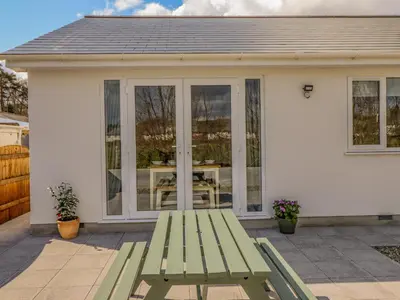 a green picnic table in front of a house at Mawnog Fach in Bala