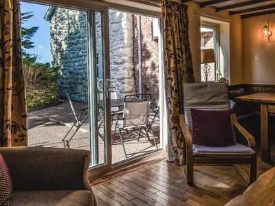 a living room with a sliding glass door at Morannedd Bach in Dyffryn