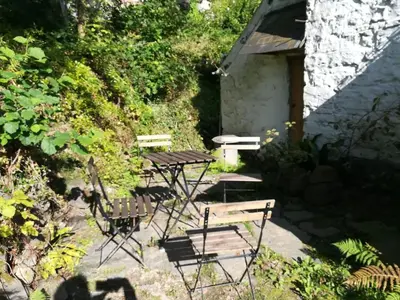 a group of chairs and a picnic table in a garden at Rhandirmwyn - Cottage - Sleeps 4 - Pet Friendly in Llandovery