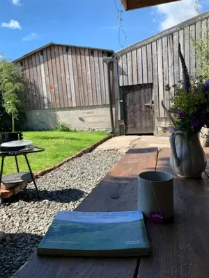 a book sitting on a wooden table in a backyard at The Pig and Sty in Hereford