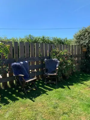 two chairs sitting in a yard next to a fence at The Pig and Sty in Hereford