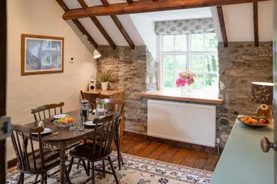 a dining room with a table and chairs and a window at Brynarth Country Cottages in Aberystwyth