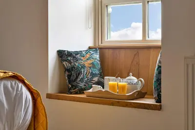 a tray with two cups of orange juice on a window sill at Finest Retreats - Moelis Granary - Luxury Cottage with Hot Tub in Llandrillo