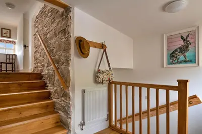 a staircase in a home with a stone wall at Finest Retreats - Moelis Granary - Luxury Cottage with Hot Tub in Llandrillo